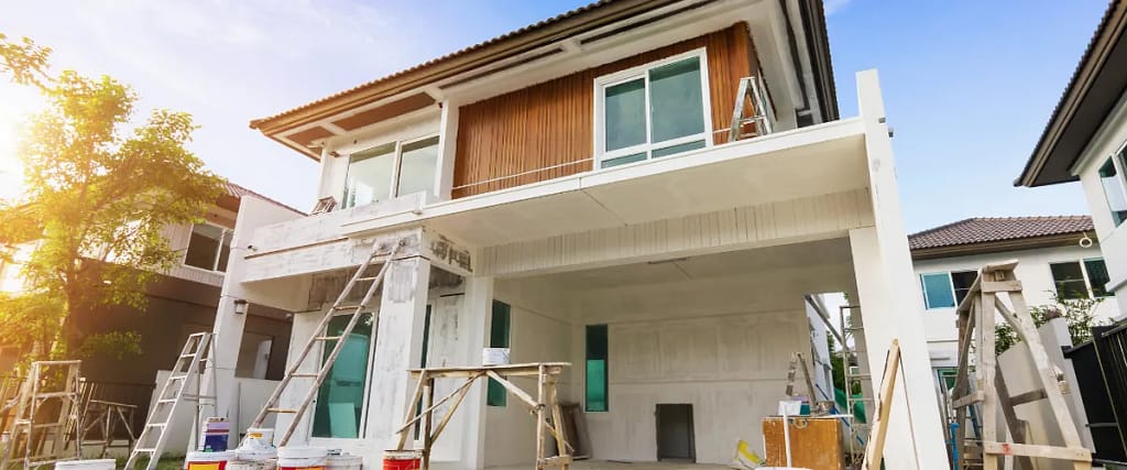 A house under construction or renovation with scaffolding and building materials in place.