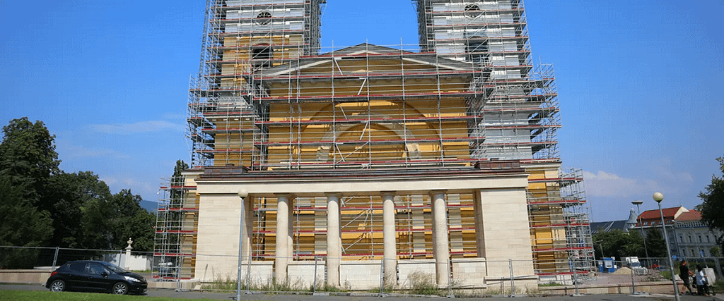 Classical building facade with columns surrounded by scaffolding