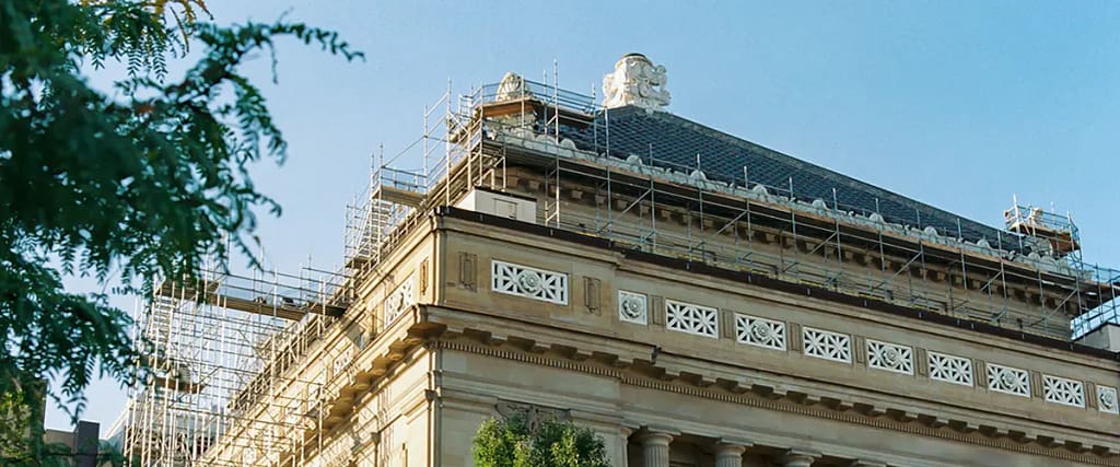 Historic brick building under restoration with heavy scaffolding